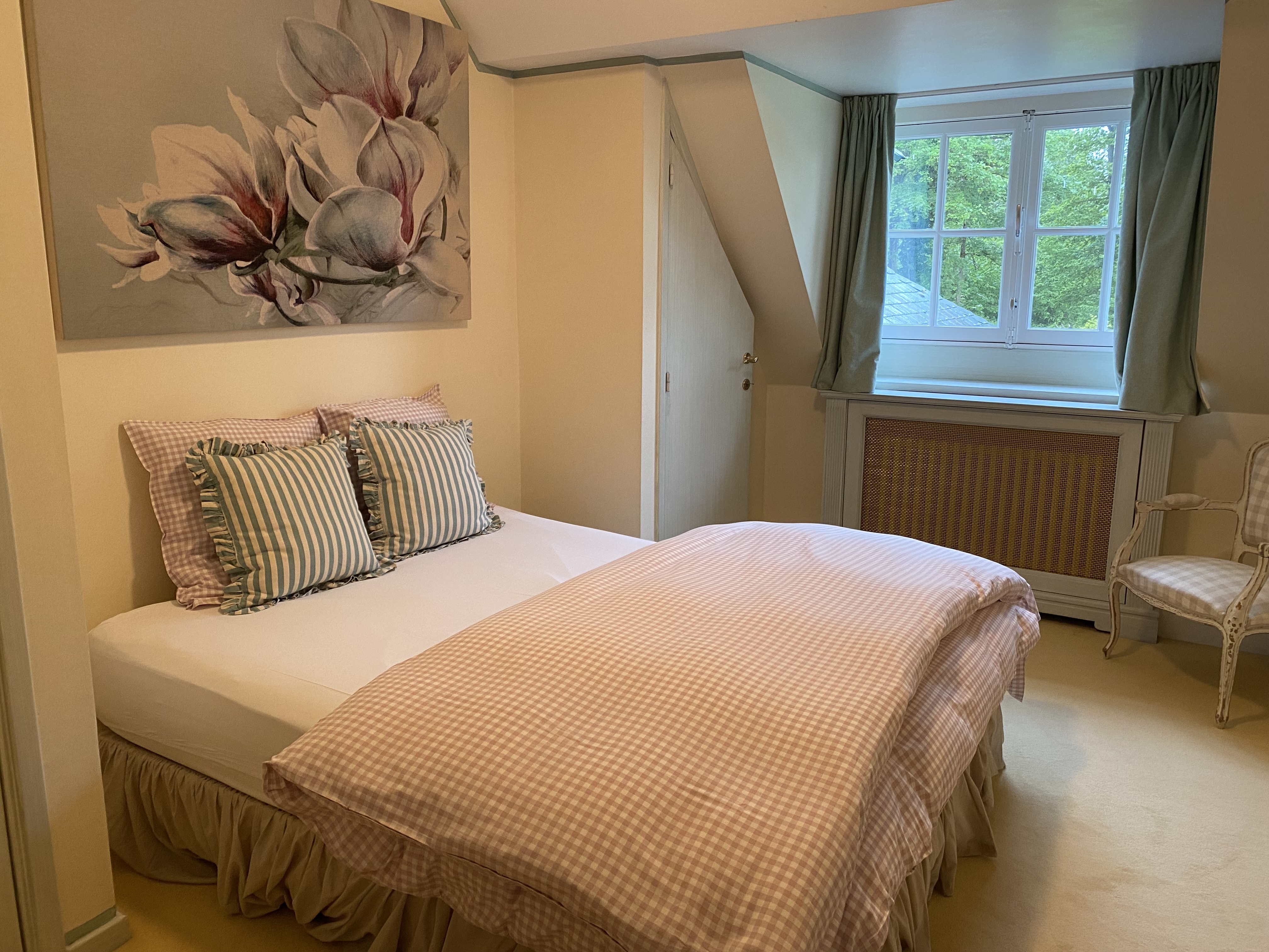 Chambre cosy avec lit à carreaux vichy roses et peinture florale