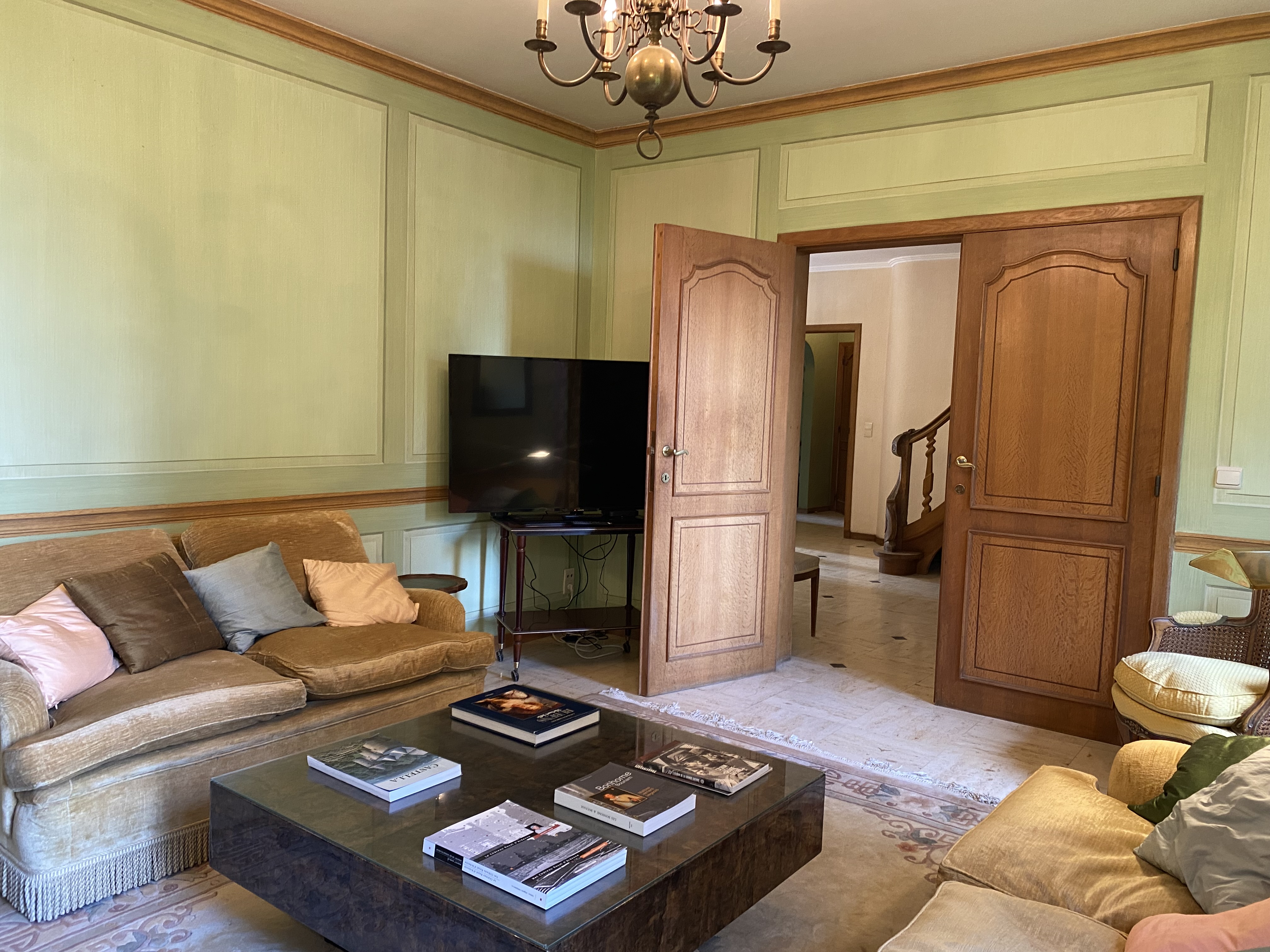 Salon élégant avec canapé en velours, table basse et vue sur le hall