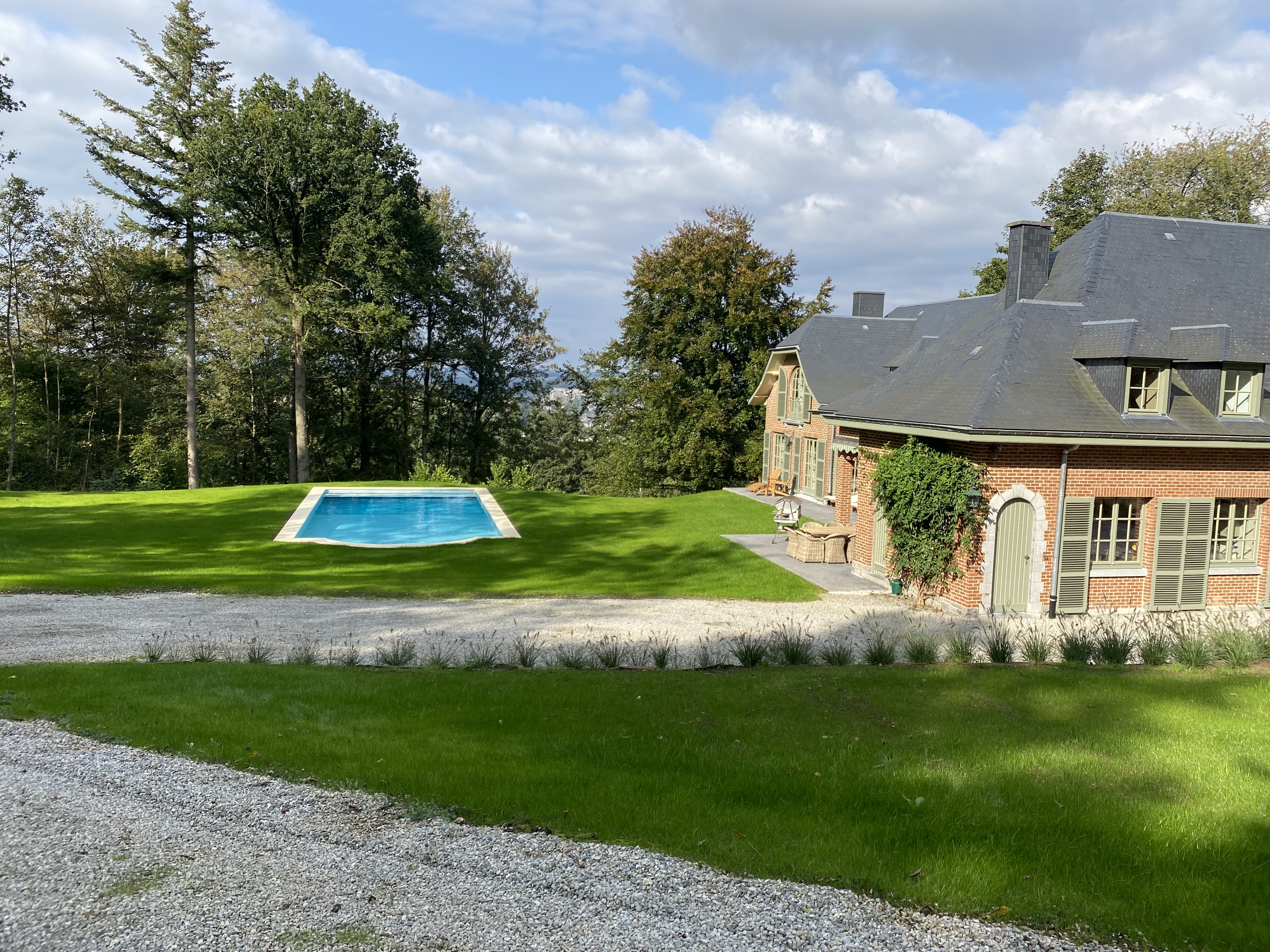 Panorama de la villa en briques avec piscine et jardin arboré