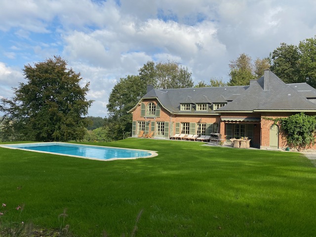 Vue extérieure de la maison avec piscine, pelouse et transats