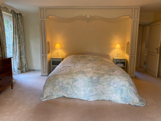 Chambre spacieuse avec lit double dans une alcôve décorative