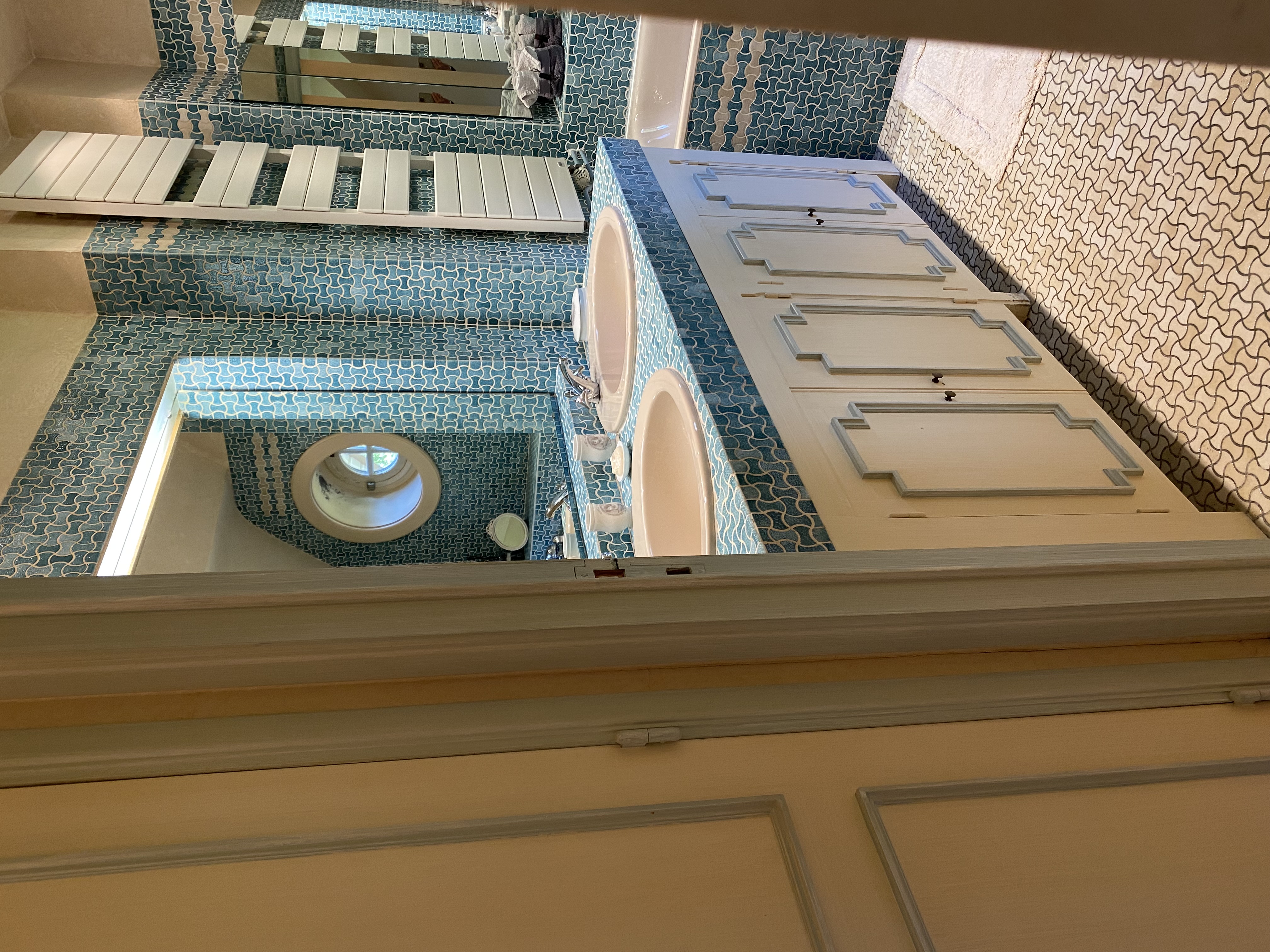 Salle de bain avec double vasque, carrelage bleu à motifs et baignoire