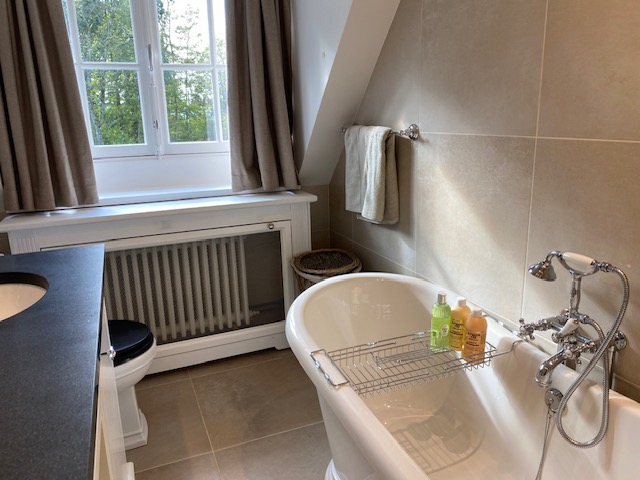 Salle de bain avec baignoire îlot, fenêtre et finitions élégantes