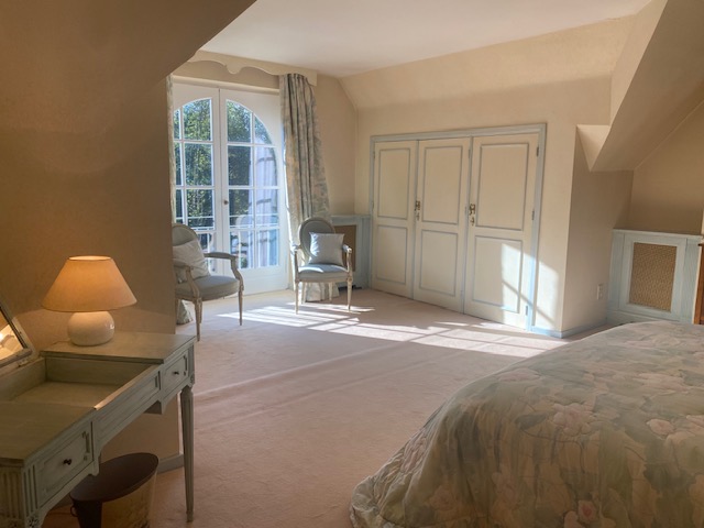 Chambre spacieuse avec placards intégrés et fenêtre arquée