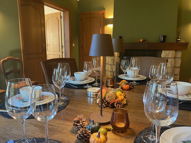 Table de salle à manger dressée avec décoration automnale et cheminée