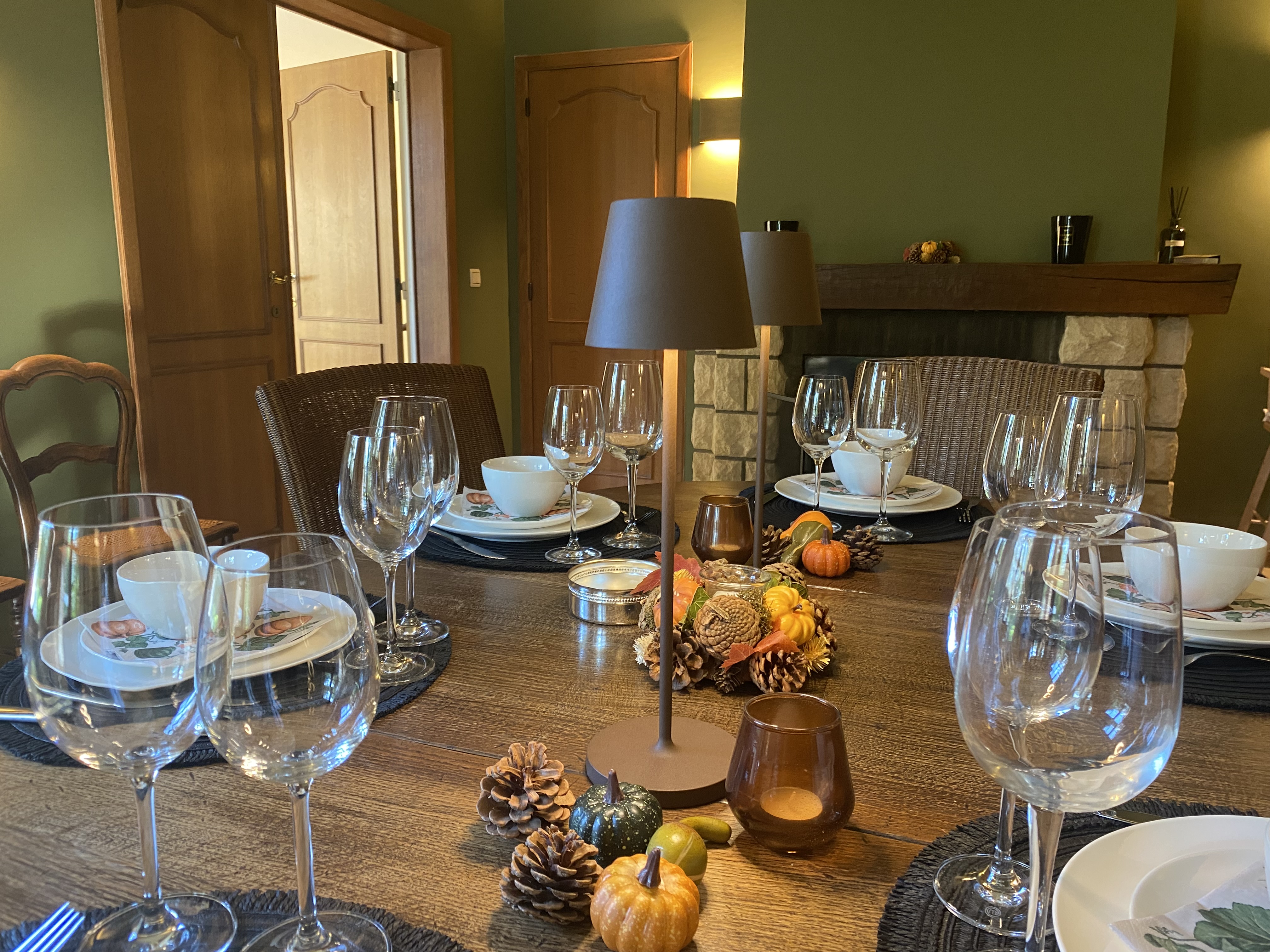 Table de salle à manger dressée avec décoration automnale et lampes d'ambiance