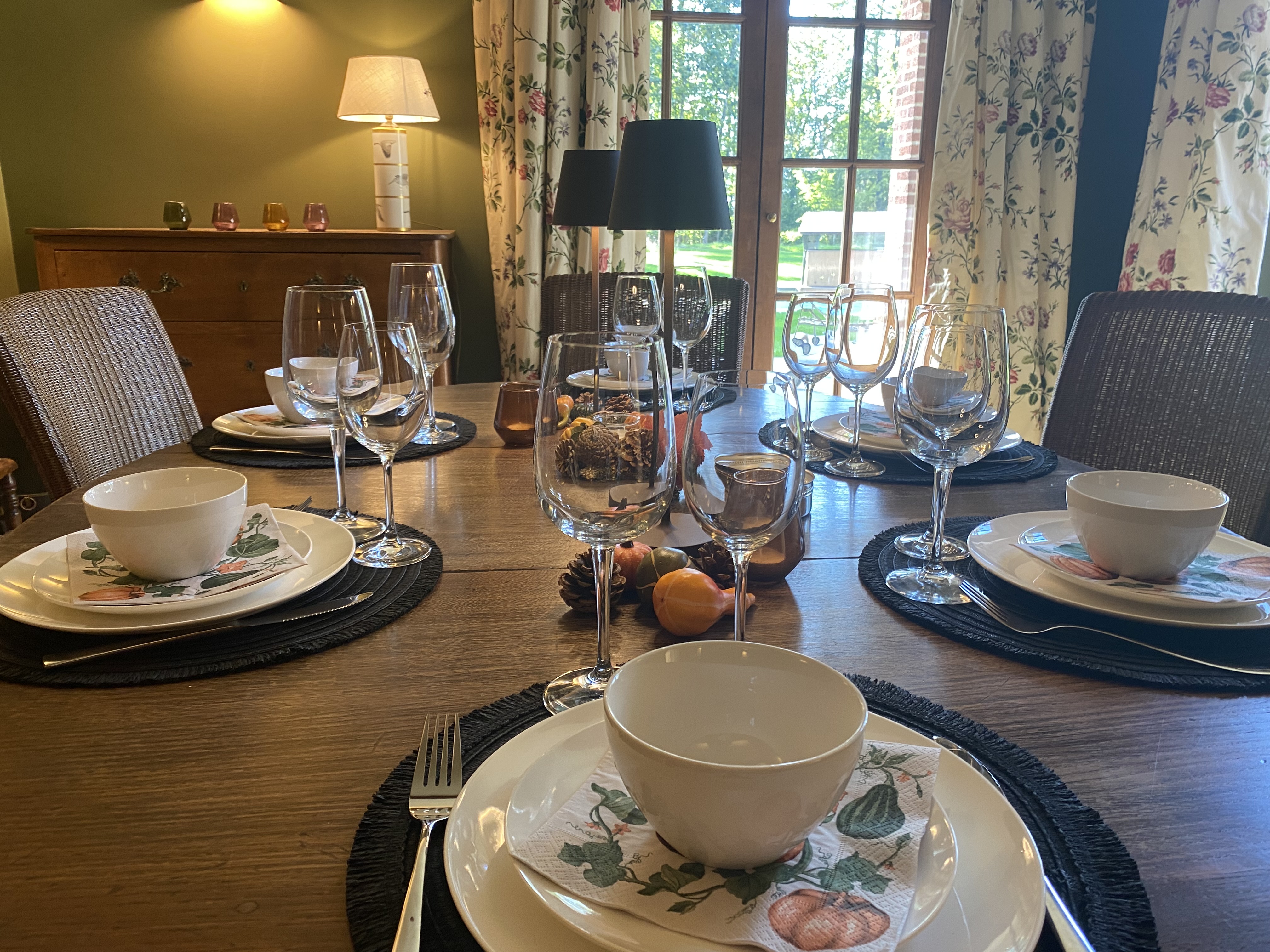 Table de salle à manger dressée avec portes-fenêtres sur le jardin