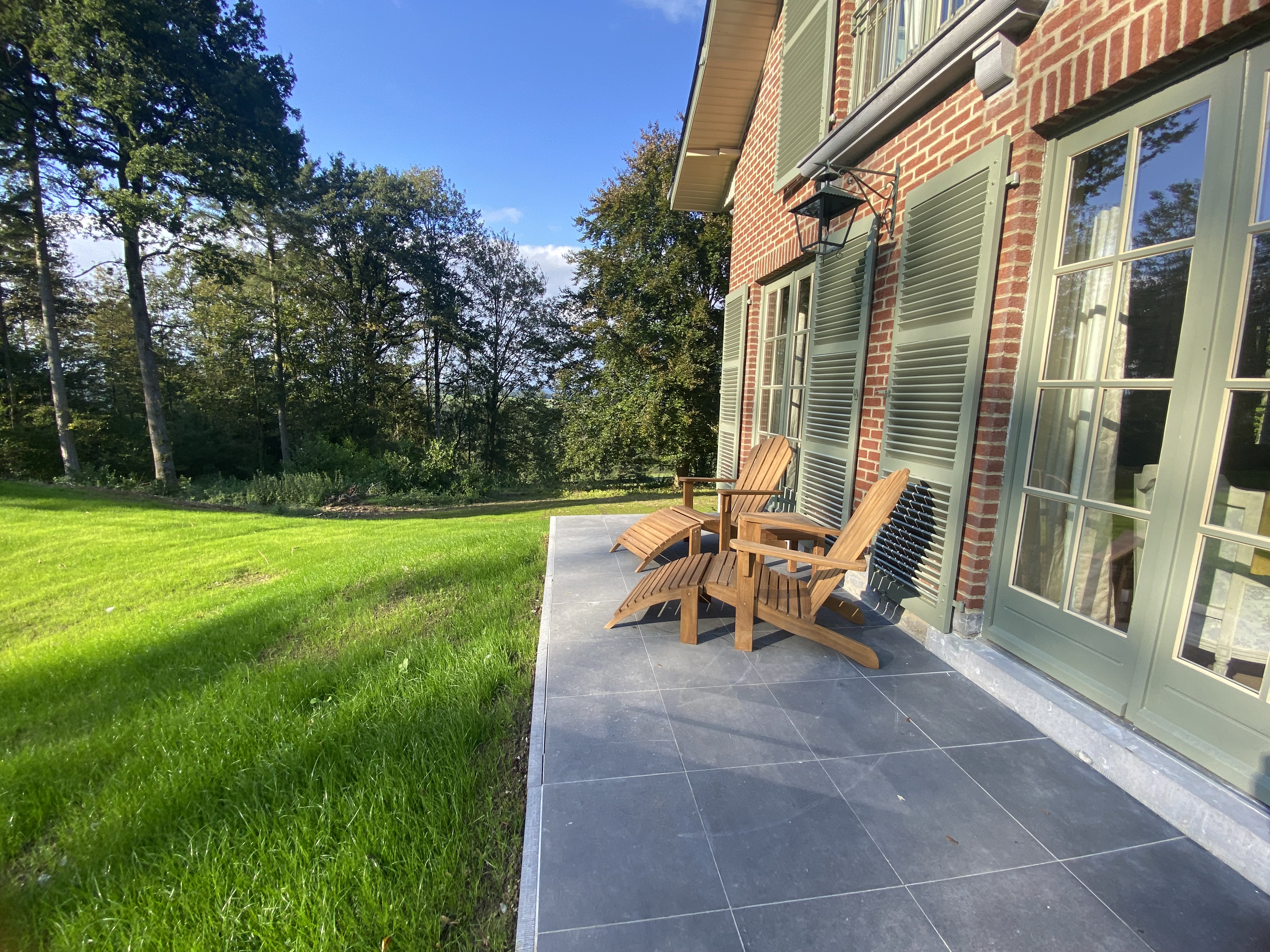 Terrasse en pierre avec chaises longues Adirondack et vue sur la forêt