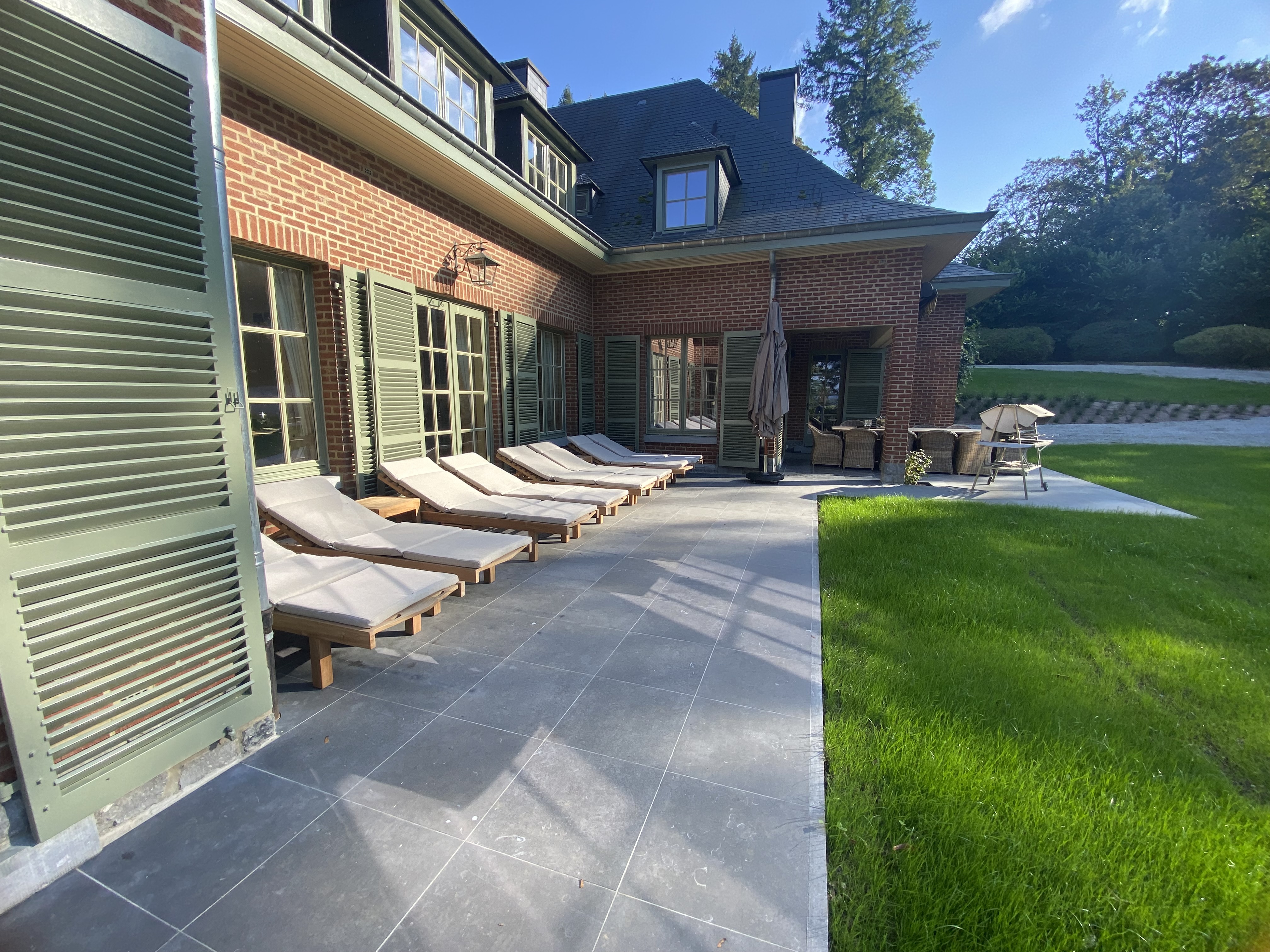 Terrasse avec chaises longues, coin repas extérieur et jardin