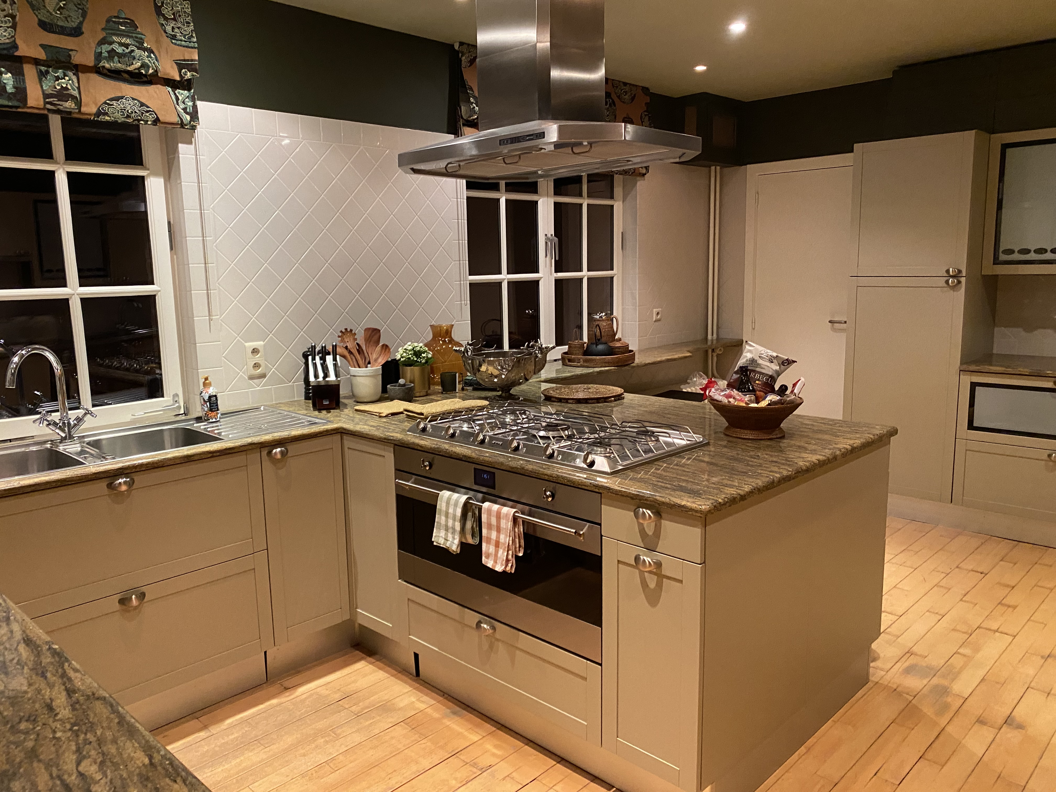 Cuisine moderne avec îlot central, piano de cuisson et finitions élégantes
